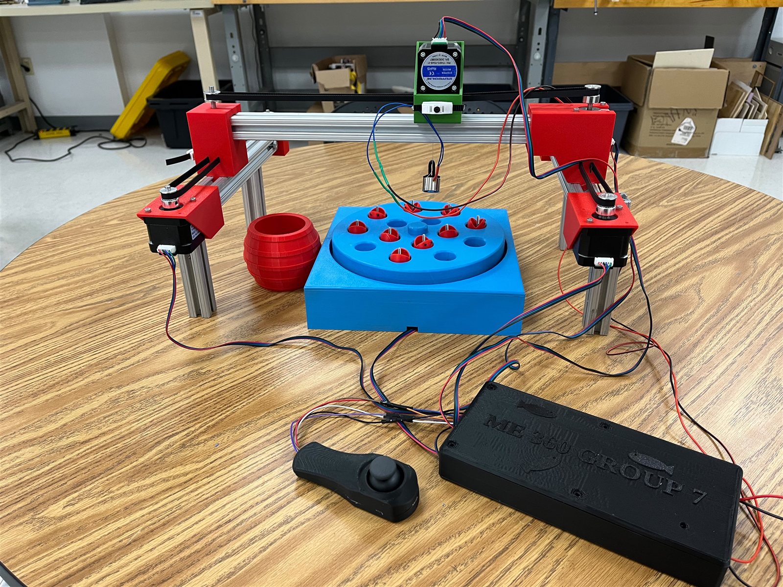 Assembled Cartesian fishing game with belt-driven gantry, rotating game board, joystick, and control enclosure